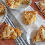 Several apple pies and slices on plate on table