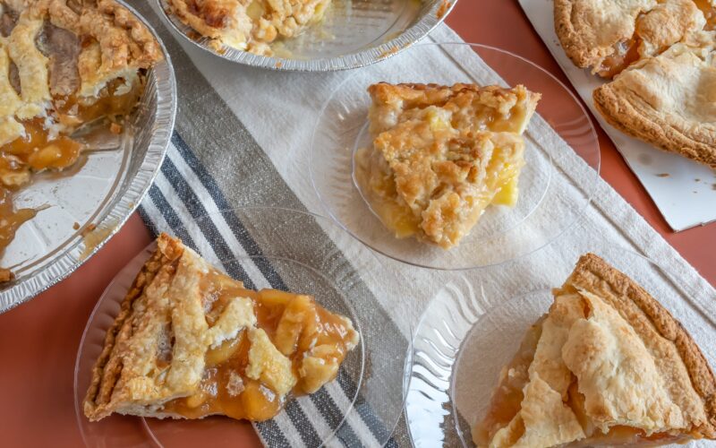 Several apple pies and slices on plate on table